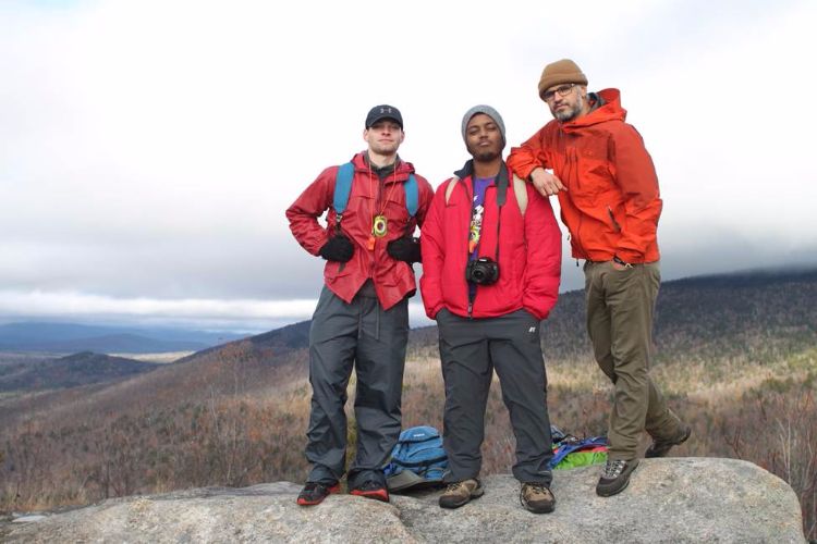 three hikers on a rock